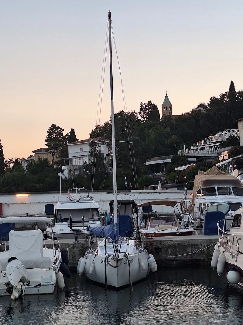 Freya bow-on at dusk with Opatija behind